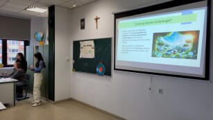 Uczennice w klasie przedstawiają prezentację na temat odnawialnych źródeł energii