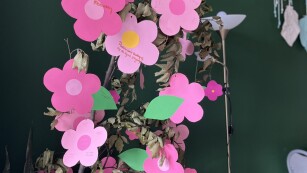 . Drzewo w donicy udekorowane różowymi kwiatami z papieru