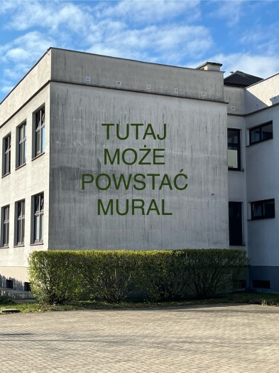 Ściana szkoły z napisem „Tutaj może powstać mural”