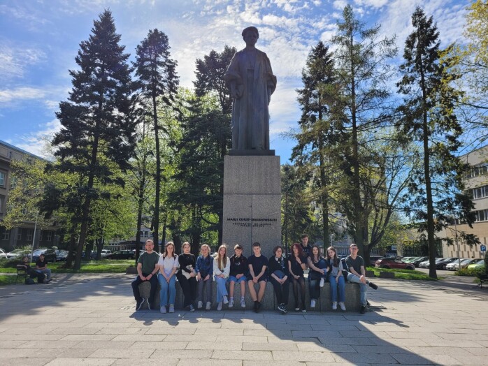 Uczniowie z wychowawcą pod pomnikiem Marii Curie – Skłodowskiej na placu głównym Dzielnicy Uniwersyteckiej