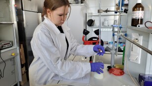 uczennica w trakcie wykonywania miareczkowania alkacymetrycznym próbki mleka mianowanym roztworem wodorotlenku sodu w obecności fenoloftaleiny jako wskaźnika.