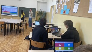 uczniowie wykonują test na laptopach