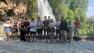 Grupa uczniów stoi na tle wodospadu w miejscowości Edessa