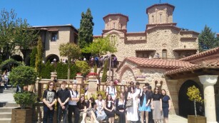 Grupa uczniów na tle prawosławnego klasztoru w Meteorach