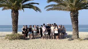 Grupa uczniów na plaży na tle Morza Egejskiego