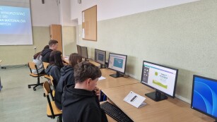 uczniowie przy stanowiskach komputerowych opracowują projekt wizytówki