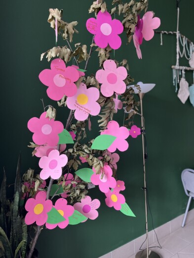 . Drzewo w donicy udekorowane różowymi kwiatami z papieru