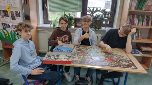 Uczniowie układają puzzle w czytelni szkolnej