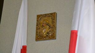 obrazek na ścianie z Matką Boską Katyńską i flagi