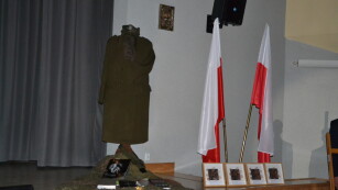 dekoracja na scenie mundur wojskowy, książki i flagi