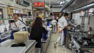 Uczniowie podczas pracy w kuchni w restauracji greckiej.